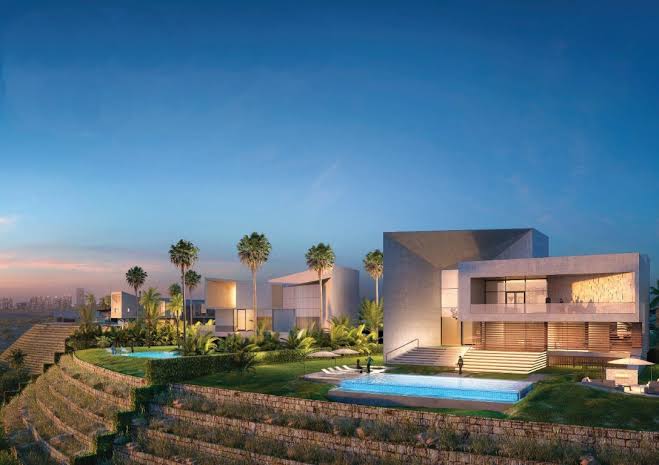 Villas of Shams Ar Riyadh at dusk with private pools, palm trees and terraced landscaping