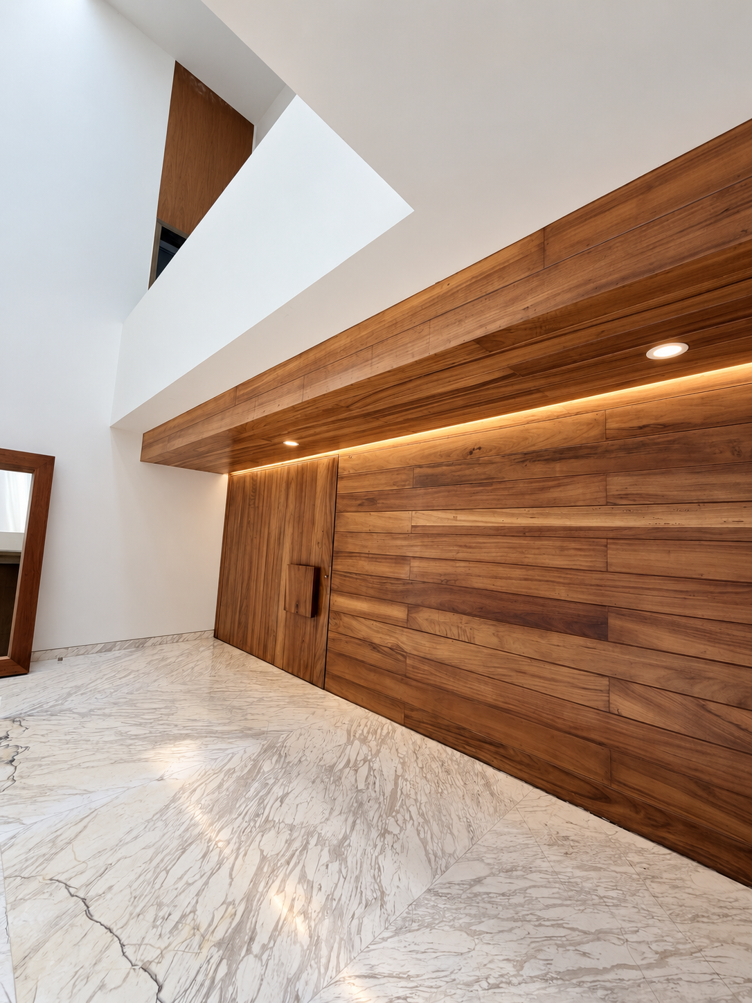 Main hall of Cedros House with full height walnut paneling, concealed pivot door and marble floor