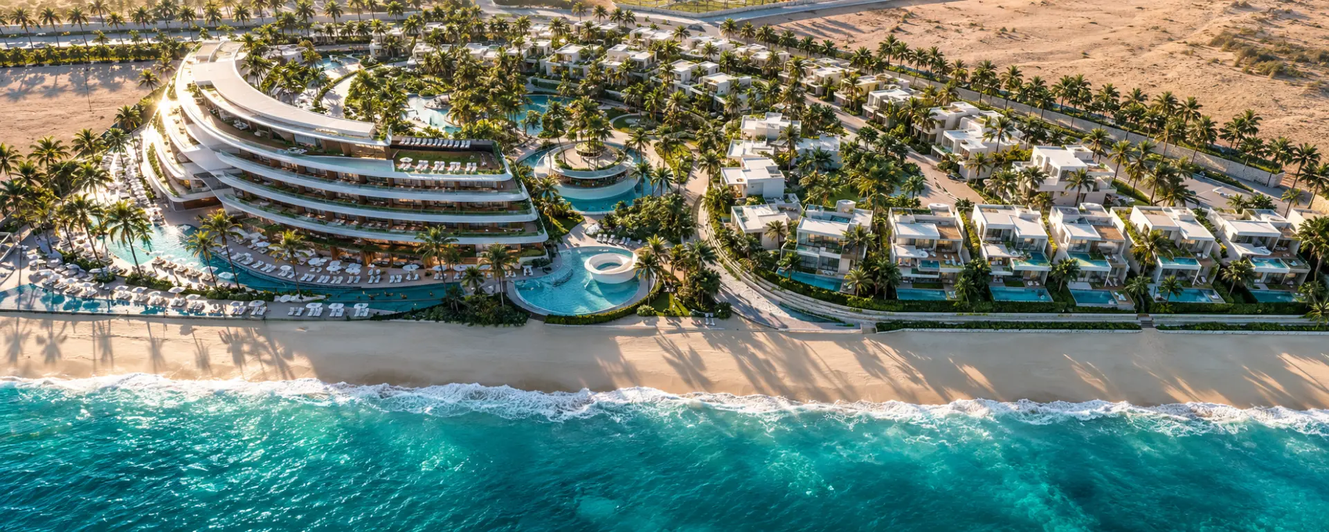 Vivienda Resort — aerial view of the curved beachfront hotel, villas, and turquoise Red Sea shoreline
